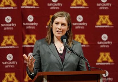 A woman standing at a podium with a microphone.